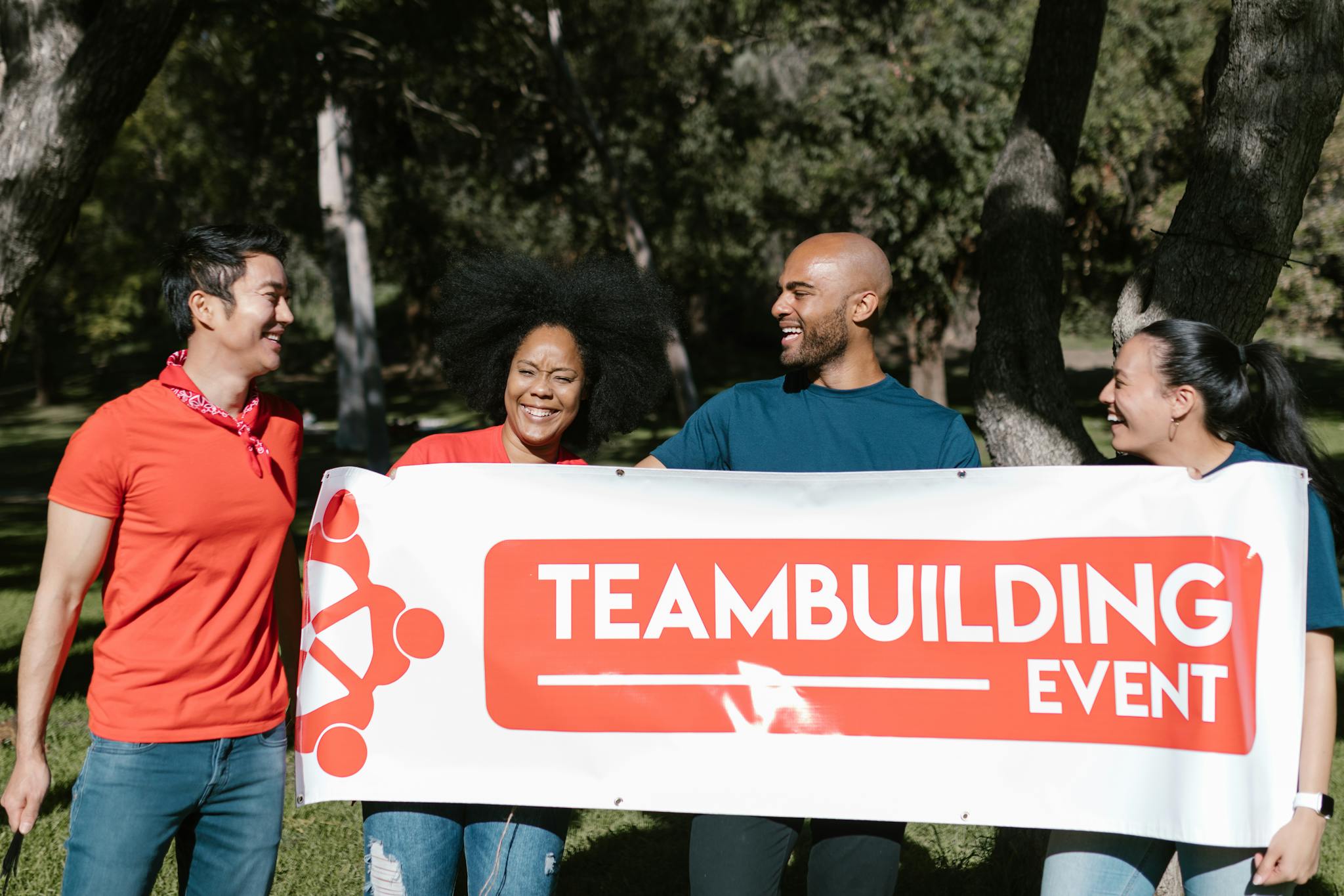 A joyful group of diverse adults at a teambuilding event in a park.